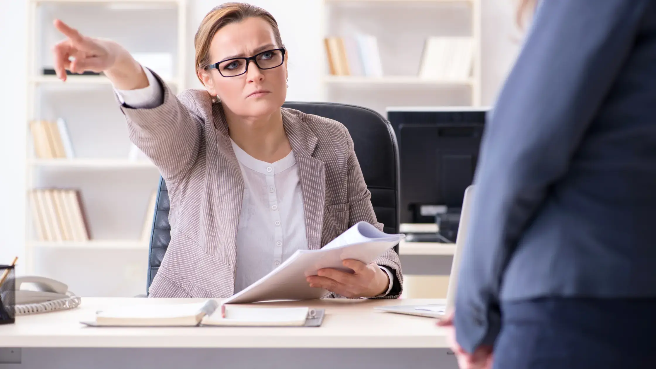 Een directrice die een werknemer met een vast contract ontslaat